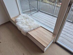 Ein Zimmer mit einer hölzernen Bank und einem weißen, flauschigen Teppich.
