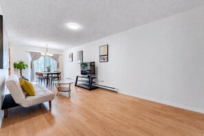 Un salon moderne avec un canapé, une table à manger et un téléviseur.