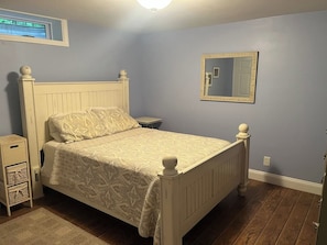 A bedroom with a bed, nightstand, and dresser. - 80-Acre Northern Michigan Lodge~Trails & Fire Pit (Wolverine)
