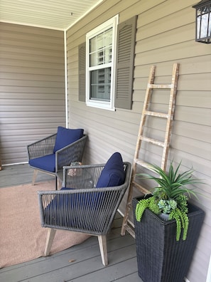 A porch with wicker chairs, a ladder, and a potted plant. - Life on the Lake, Come on down to South GA, only three miles to the Fl. line (Lake Park)