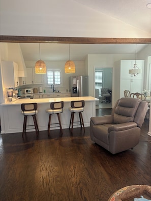 A modern kitchen with a central island, bar stools, and a leather chair. - Life on the Lake, Come on down to South GA, only three miles to the Fl. line (Lake Park)