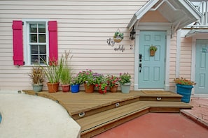A house with a porch, potted plants, a door with a welcome sign, and a mailbox. - Cozy 1-bedroom studio apartment with a perfect blend of style and tranquility (Nassau)