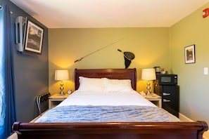 A hotel room with a bed, two bedside tables, a TV, and a wall-mounted lamp.