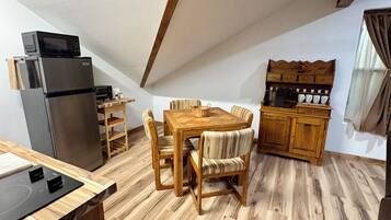 Una cocina compacta con refrigerador, microondas y armarios de madera.