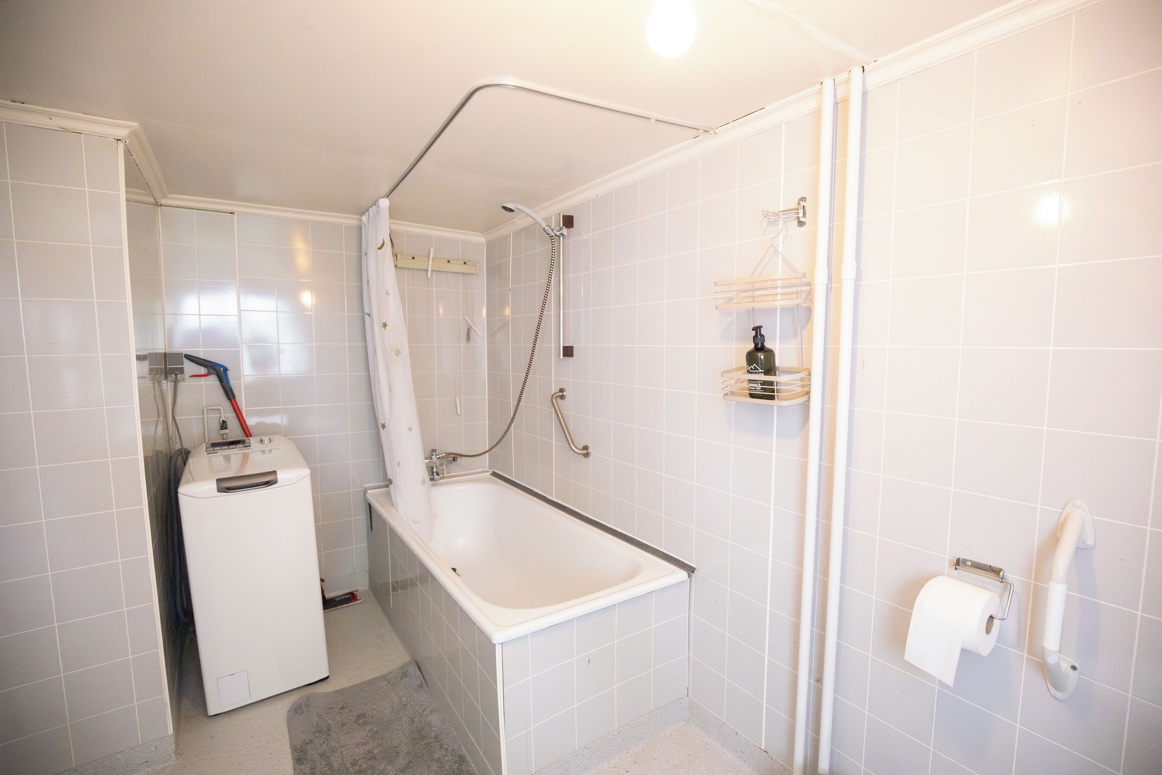 A bathroom with a shower, a toilet, and a sink.