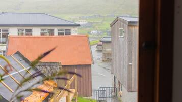 A view from a window overlooking a rural landscape with buildings and a road.