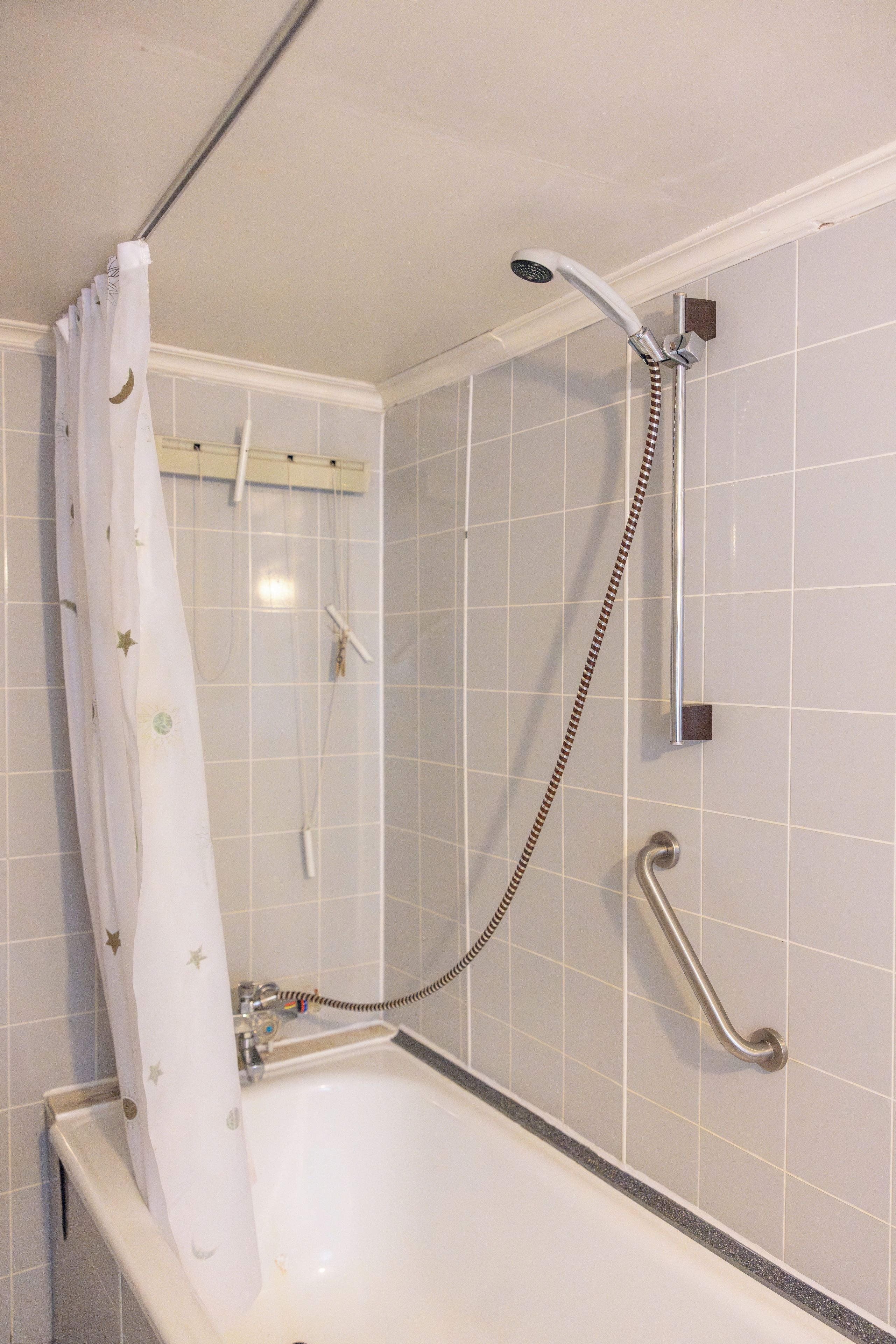 A bathroom with a shower, a bathtub, and a grab bar.