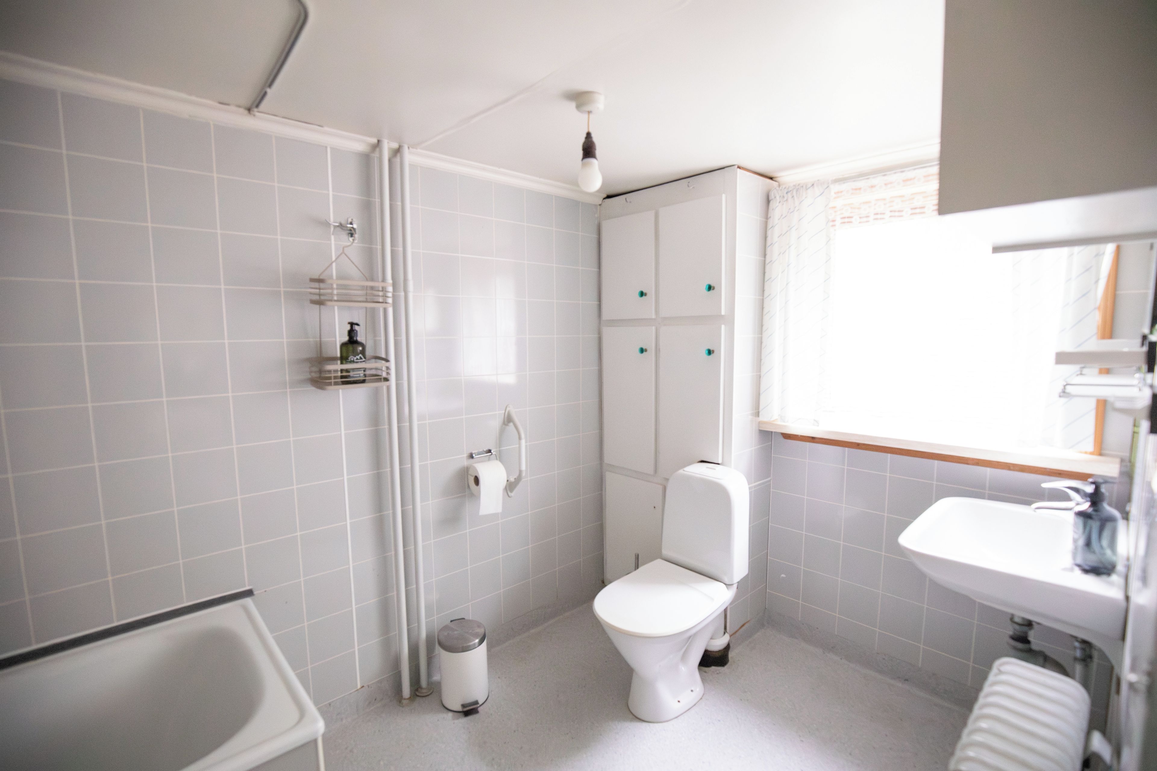 A bathroom with a toilet, sink, and shower area.