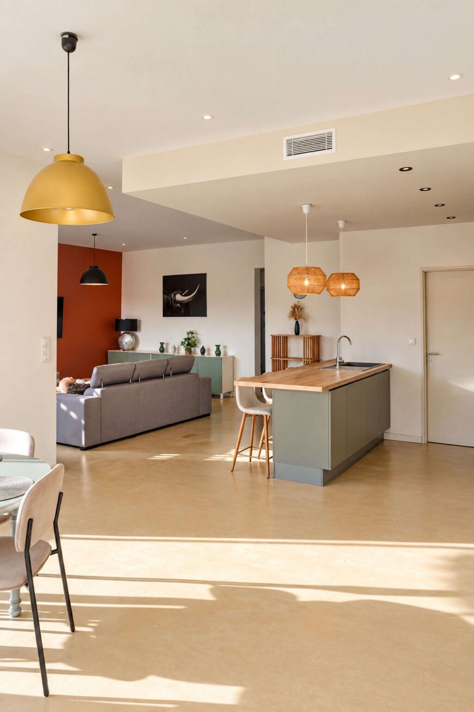 Um interior moderno com ilha de cozinha, área de jantar e sala de estar.