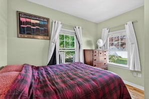 A bedroom with a bed, dresser, windows, and a painting on the wall. - Beautiful 5-bedroom house with AC 5-min walk to Old Orchard Beach (Old Orchard Beach)