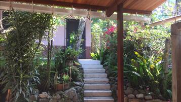 A covered outdoor staircase surrounded by lush greenery and plants.