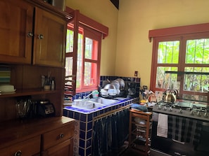 A kitchen with wooden cabinets, a tiled backsplash, a sink, and a stove.