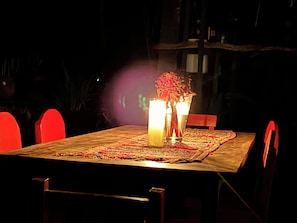 A dining table with chairs, candles, and a centerpiece.