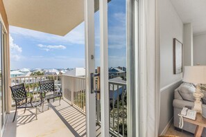 Ein Balkon mit Blick auf ein Wohngebiet, ein Stuhl, ein Tisch und eine Lampe.