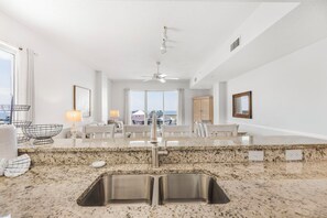 Eine moderne Küche mit Granit Arbeitsplatten, Spüle aus Edelstahl und einem Essbereich mit Blick.