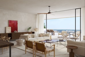 A modern living room with a sofa, coffee table, chairs, and a view of the ocean.