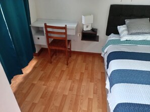 A bedroom with a bed, a desk, and a chair. - 2-Bedroom, 2-Bathroom Apartment, 15 Minutes from the Airport (Lima)