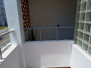A balcony with a metal railing, a view of the street, and a building with a grey facade. - 2-bedroom, 2-bathroom apartment, 15 minutes from the airport (Lima)