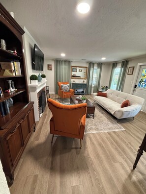 A living room with a fireplace, a sofa, a coffee table, and a television mounted on the wall. - La hermosa casa del lago. St Cloud. Florida (St. Cloud)