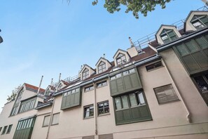 A multi-story building with a flat roof, dormer windows, and a visible chimney. - Modern Stay near Kahlenberg & Vineyards (Wien)