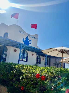 A building with a sign that reads 'HOTEL RESTAURANT' and a blue elephant symbol.
