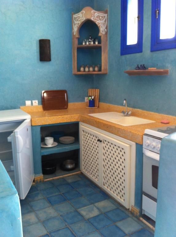 Une cuisine de taille réduite, équipée d’un évier, d’une cuisinière et de placards de rangement.