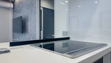A modern kitchen with a sleek countertop, a built-in oven, and a large mirror.