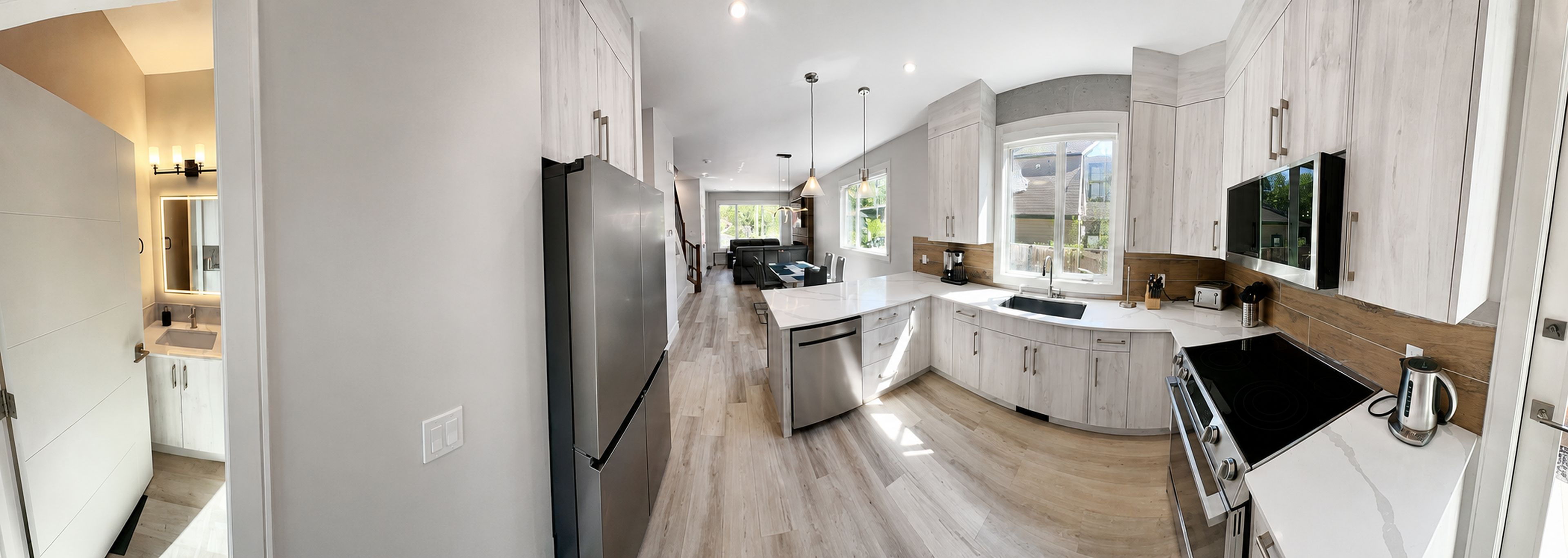 Una cocina moderna con una isla central, electrodomésticos de acero inoxidable y un amplio ventanal que proporciona luz natural.