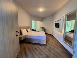 A modern bedroom with a large bed, bedside tables, a flat-screen TV, and a mirror. - porto view (Hurghada)