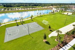 Ein Basketballplatz mit einem Wasserspiegel und Palmen.