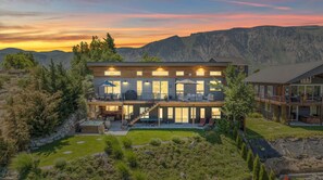 A modern two-story house with a balcony, a patio, and a view of mountains. - Wapato Waters-your Manson getaway-lakefront, family-friendly, dock, and hot tub. (Manson)