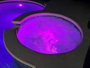Ein Whirlpool mit gewölbtem Rand und gefliestem Innenraum.