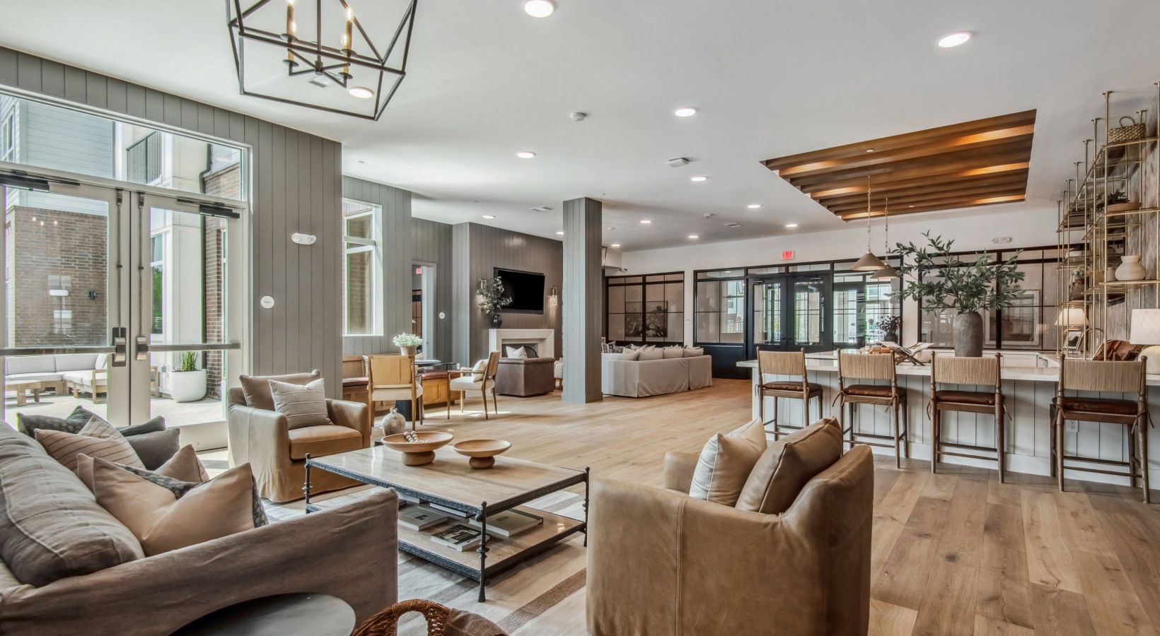 A spacious living area with a large sofa set, a coffee table, and a dining area with bar stools.