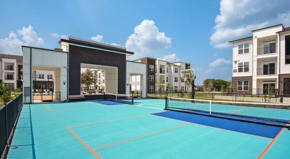 A tennis court with a net, surrounded by apartment buildings. - Modern 2BR 2BA | Open Layout MER 1307 (San Marcos)