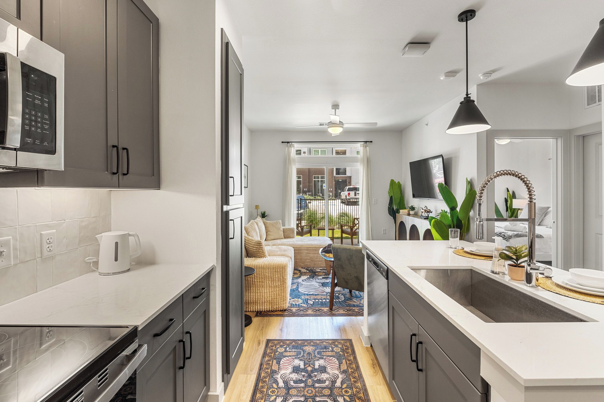 A modern kitchen with a microwave, coffee maker, and a dining area with a sofa and chairs.
