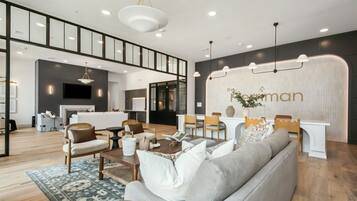 A modern living room with a fireplace, seating area, and a dining space.