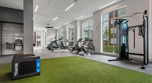 A modern gym with stationary bikes, a treadmill, and a weight machine. - Stylish 1BR Stay | Pool + Luxe Amenities MER 3106 (San Marcos)