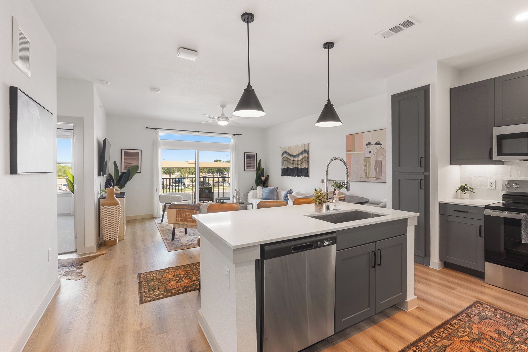 Una cocina moderna con una isla central, electrodomésticos de acero inoxidable y vistas al exterior.