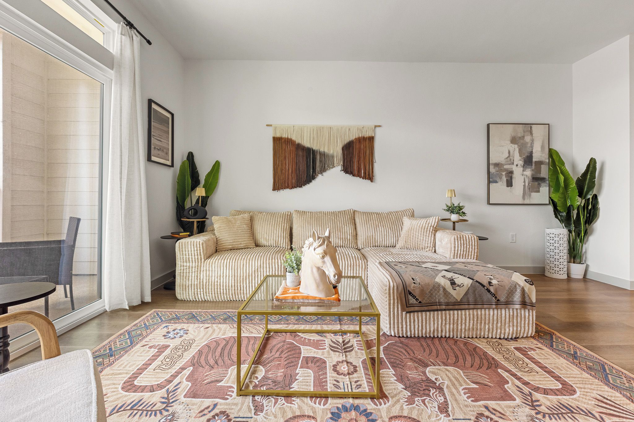 Een moderne woonkamer met een bank, salontafel en decoratieve objecten.