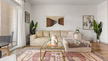 Een moderne woonkamer met een bank, salontafel en decoratieve objecten.