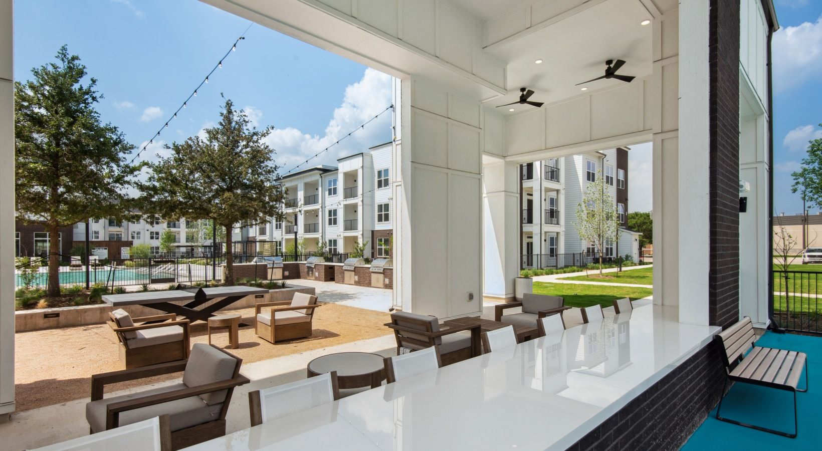 Un área de patio al aire libre con asientos y vista a la piscina.
