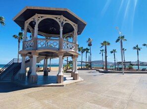 A gazebo with a balcony overlooking a beach, palm trees, and a clear sky. - Casa Madero #1, 1 block from the Malecón (La Paz)