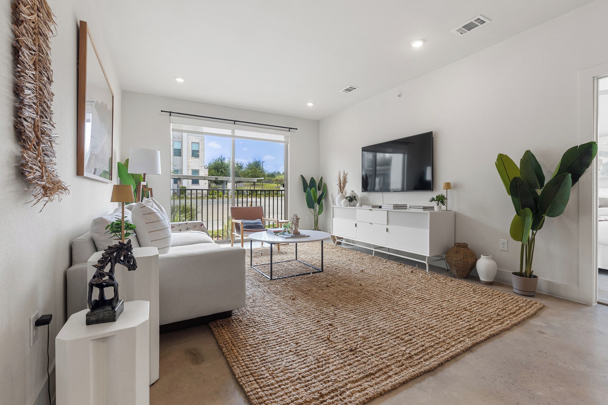 A modern living room with a sofa, coffee table, and a flat-screen TV.