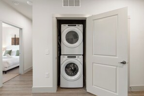 A laundry room with two stacked front-loading washers and dryers.