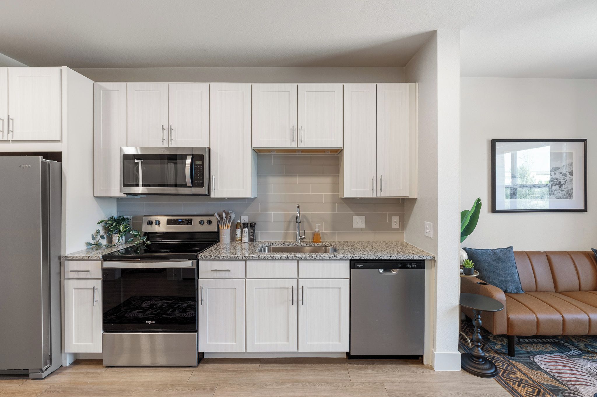 A modern kitchen with white cabinetry, stainless steel appliances, and a dishwasher.