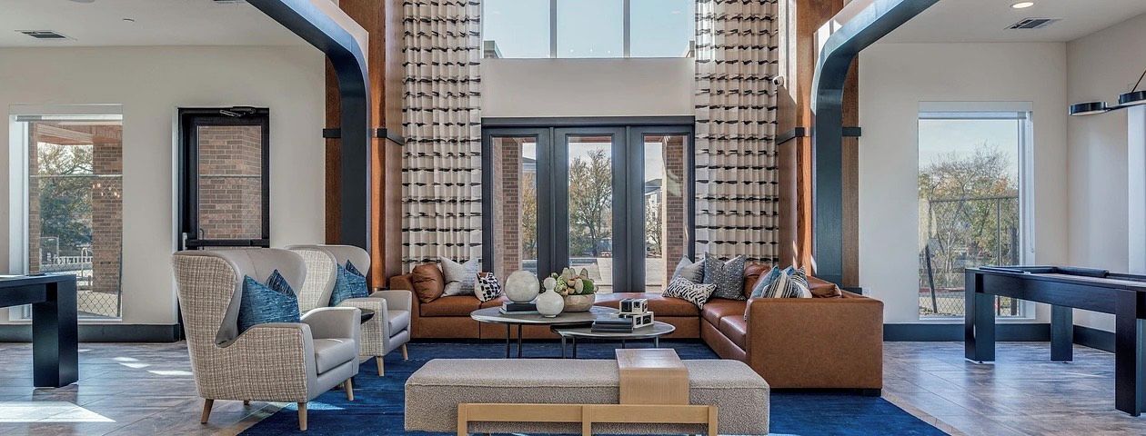 A spacious living area with a pool table, comfortable seating, and large windows.