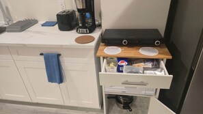 Een aanrecht met een broodrooster, koffiezetapparaat en een zwart apparaat erop.