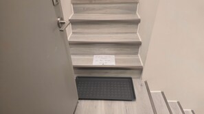 A staircase with a sign instructing to place shoes in the tray below. - New Modern 1BR Suite With Private Entrance - Easy Access To Malls (Winnipeg)