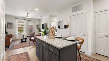 A modern kitchen with dark cabinetry, a granite countertop, and a decorative horse head sculpture.