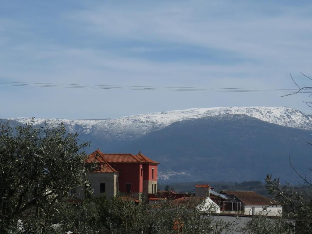 Un quartier résidentiel avec des maisons, dont certaines ont des toits rouges, et une montagne enneigée en arrière-plan.
